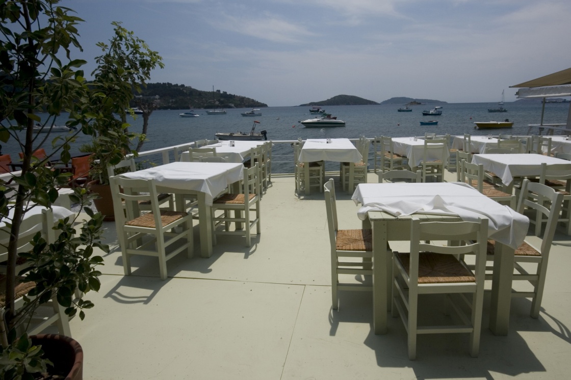 'Dining tables in local restaurant with a view of the sea Skiathos, Greece' - Skiathos